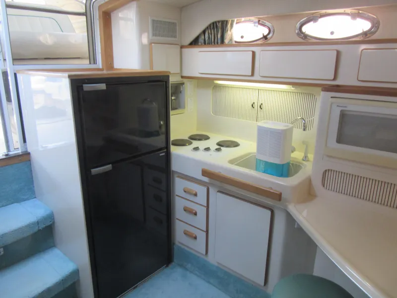 Slide: The Image of 1995 Sea Ray 400 Express Cruiser kitchen with fridge, stove, and microwave. - 28