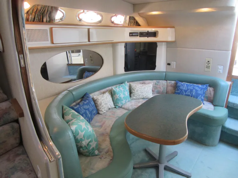 Slide: The Image of 1995 Sea Ray 400 Express Cruiser interior with curved seating and decorative pillows. - 31