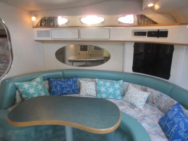 Slide: The Image of 1995 Sea Ray 400 Express Cruiser interior with curved seating and decorative pillows. - 32