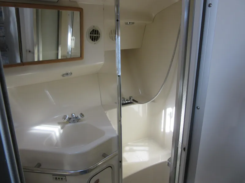 Slide: The Image of 1995 Sea Ray 400 Express Cruiser bathroom with sink, mirror, and shower. - 38