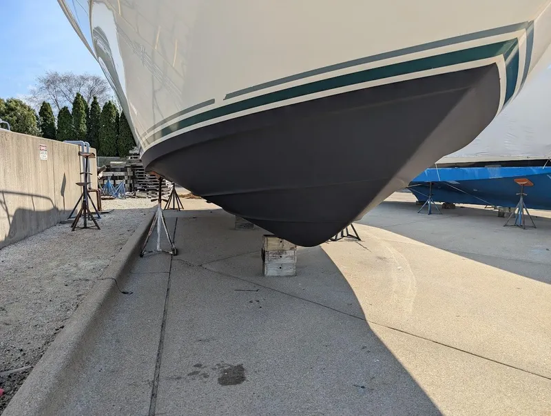 Slide: The Image of 1995 Sea Ray 400 Express Cruiser on dry dock, showcasing hull and support stands. - 8