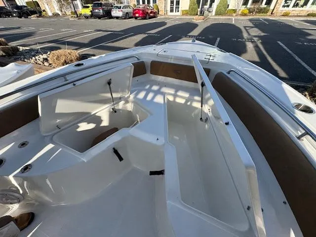 Slide: The Image of 2022 Sea Hunt Ultra 234 boat interior with open storage compartments in a parking lot. - 14