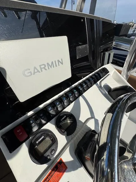 Slide: The Image of 2022 Sea Hunt Ultra 234 dashboard with Garmin navigation system and controls. - 4