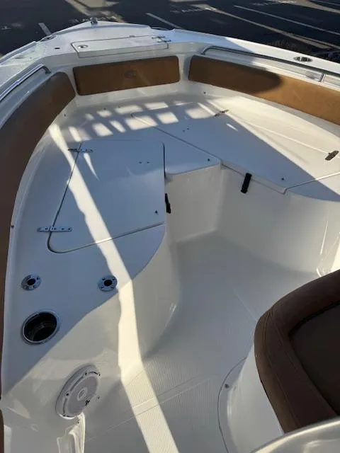 Slide: The Image of 2022 Sea Hunt Ultra 234 boat interior with white seating and brown accents. - 8