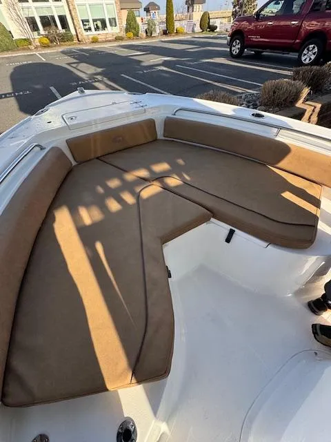 Slide: The Image of 2022 Sea Hunt Ultra 234 boat with tan cushioned seating in a sunny outdoor setting. - 9