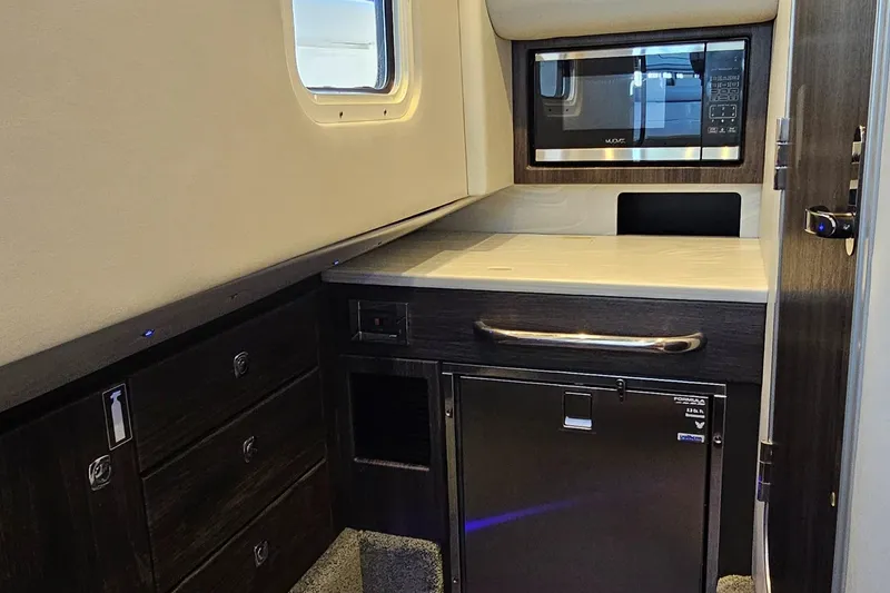 Slide: The Image of 2021 Formula 350 CBR cabin interior with kitchenette, featuring microwave and storage drawers. - 23