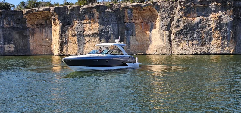 Slide: The Image of 2021 Formula 350 CBR boat cruising near rocky cliffs on a sunny day. - 6