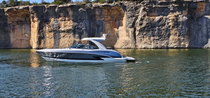 Slide: The Image of 2021 Formula 350 CBR boat cruising on a serene lake with rocky cliffs in the background. - 7