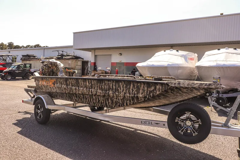 Slide: The Image of 2025 Excel 1754 F4 Shallow Water boat on trailer, parked outside a dealership. - 3
