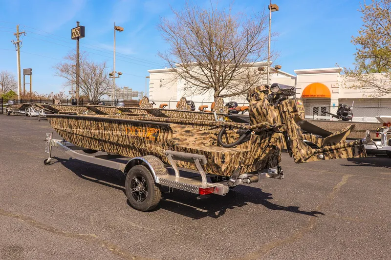 Slide: The Image of 2025 Excel 1754 F4 Shallow Water boat with camouflage design on a trailer in a parking lot. - 7