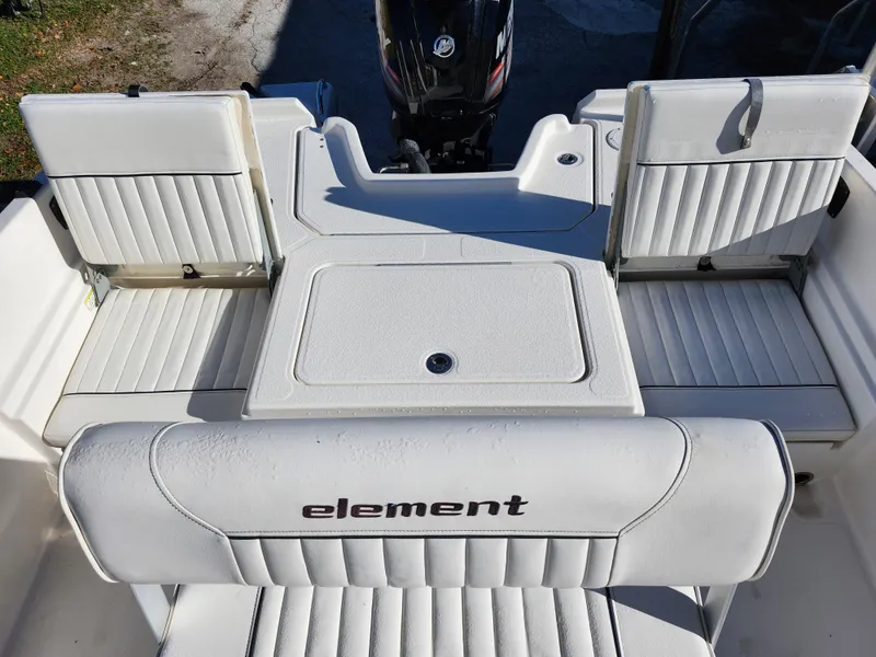 Slide: The Image of 2018 Bayliner Element F21 boat interior with white seating and motor. - 10