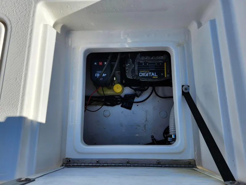 Slide: The Image of 2018 Bayliner Element F21 boat battery compartment with digital charger and wiring. - 16