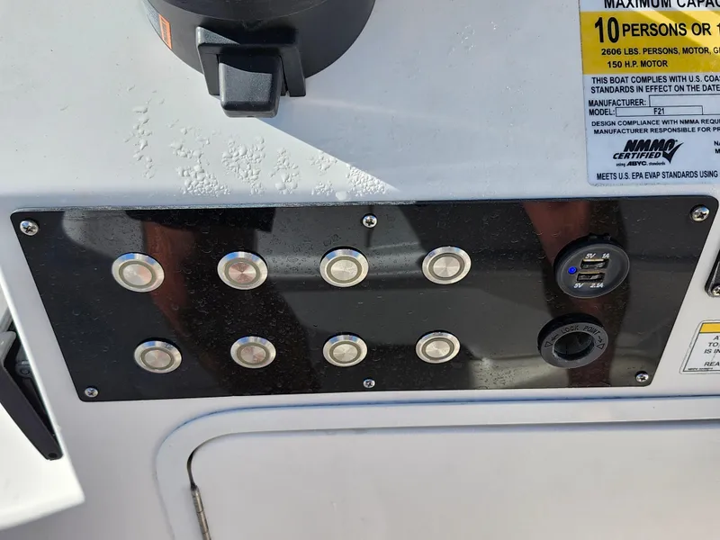 Slide: The Image of Control panel of 2018 Bayliner Element F21 boat with switches and capacity label. - 27