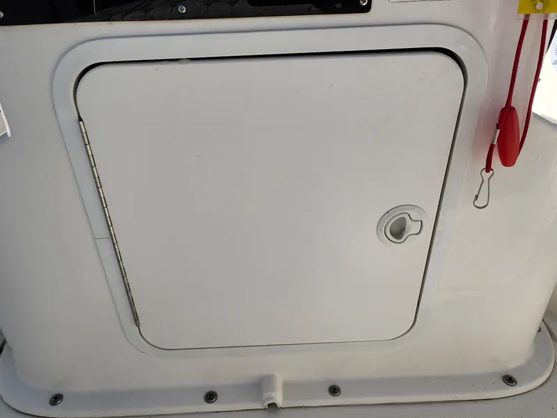 Slide: The Image of 2018 Bayliner Element F21 boat storage compartment with latch and safety lanyard. - 28