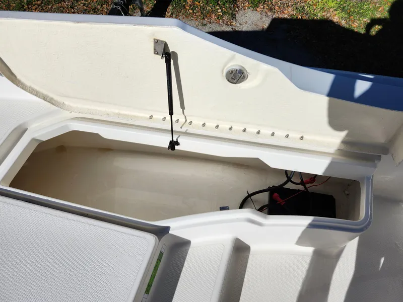 Slide: The Image of 2018 Bayliner Element F21 boat storage compartment with open lid and visible battery. - 40