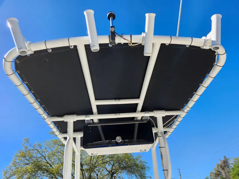 Slide: The Image of 2018 Bayliner Element F21 boat canopy with rod holders against clear blue sky. - 48