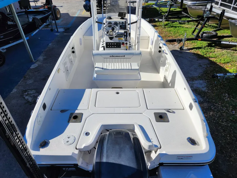 Slide: The Image of 2018 Bayliner Element F21 boat interior with console and seating, docked outdoors. - 8