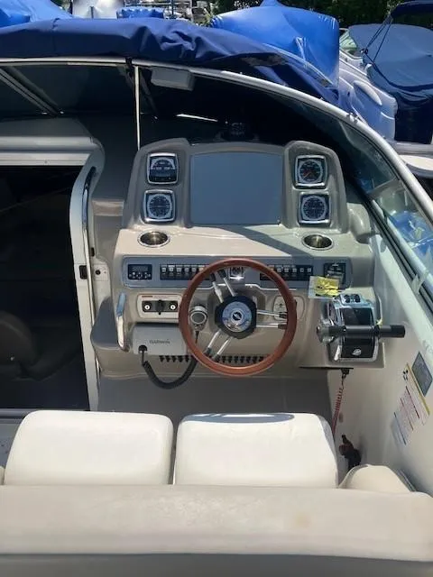 Slide: The Image of 2013 Chaparral 290 Signature boat helm with modern controls and wooden steering wheel. - 3