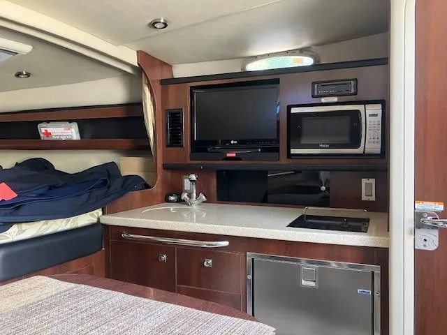 Slide: The Image of Interior of 2013 Chaparral 290 Signature boat with kitchenette and modern amenities. - 6