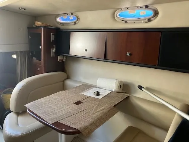 Slide: The Image of Interior of 2013 Chaparral 290 Signature boat with dining area and storage cabinets. - 8