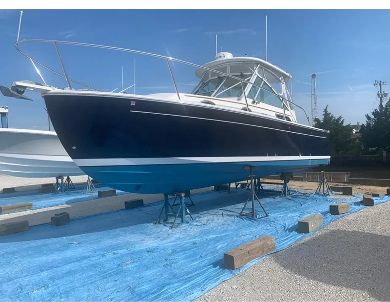 Slide: The Image of 2006 Back Cove 29 boat on stands, blue hull, outdoor display. - 1