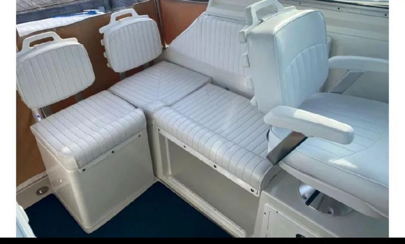 Slide: The Image of 2006 Back Cove 29 boat interior with white cushioned seating and armchair. - 5