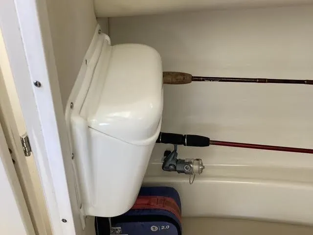 Slide: The Image of 2008 Boston Whaler 235 Conquest interior with fishing rods and storage compartment. - 11