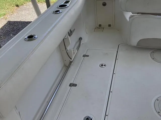 Slide: The Image of 2008 Boston Whaler 235 Conquest boat interior, featuring rod holders and storage compartments. - 15