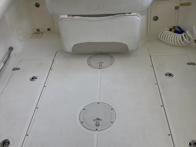 Slide: The Image of 2008 Boston Whaler 235 Conquest boat deck with storage hatches and coiled hose. - 16