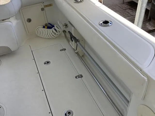 Slide: The Image of 2008 Boston Whaler 235 Conquest boat interior with storage compartments and coiled hose. - 17