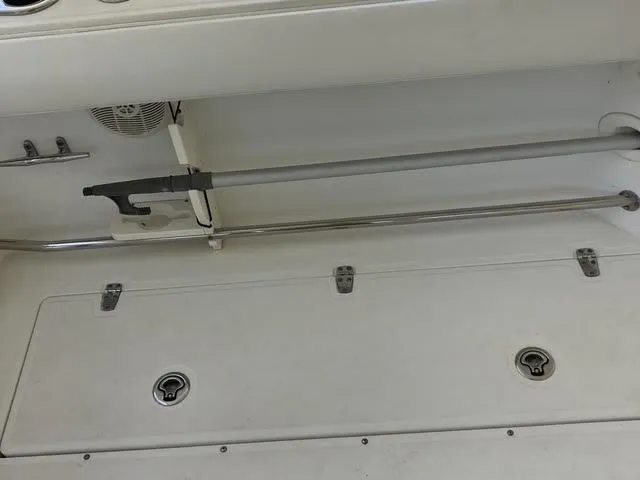 Slide: The Image of 2008 Boston Whaler 235 Conquest boat interior with storage compartments and rod holder. - 19