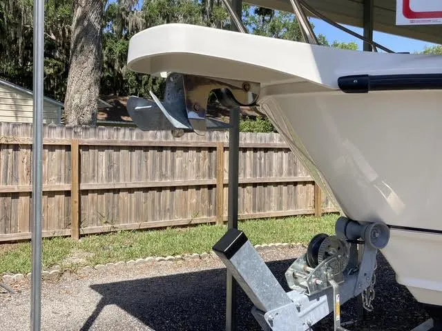 Slide: The Image of 2008 Boston Whaler 235 Conquest boat on trailer, parked near wooden fence. - 24