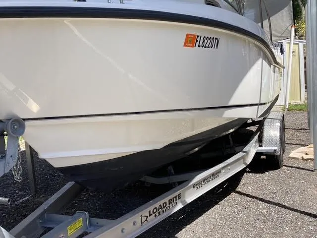 Slide: The Image of 2008 Boston Whaler 235 Conquest boat on Load Rite trailer, parked outdoors. - 25