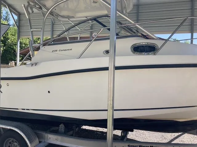 Slide: The Image of 2008 Boston Whaler 235 Conquest boat on trailer in covered storage. - 36