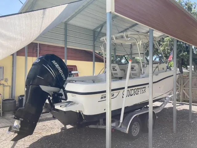Slide: The Image of 2008 Boston Whaler 235 Conquest boat on trailer under metal canopy. - 37