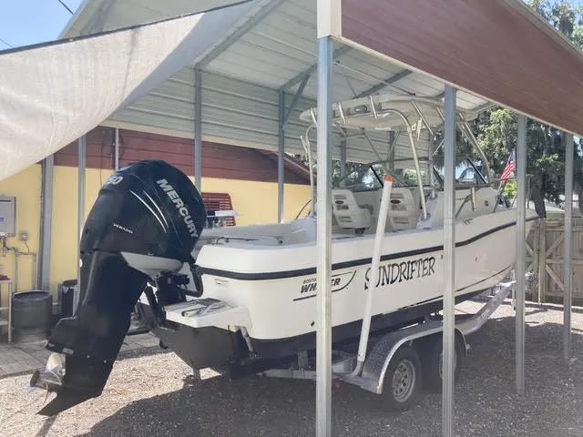 Slide: The Image of 2008 Boston Whaler 235 Conquest boat on trailer under shelter, featuring Mercury outboard motor. - 38
