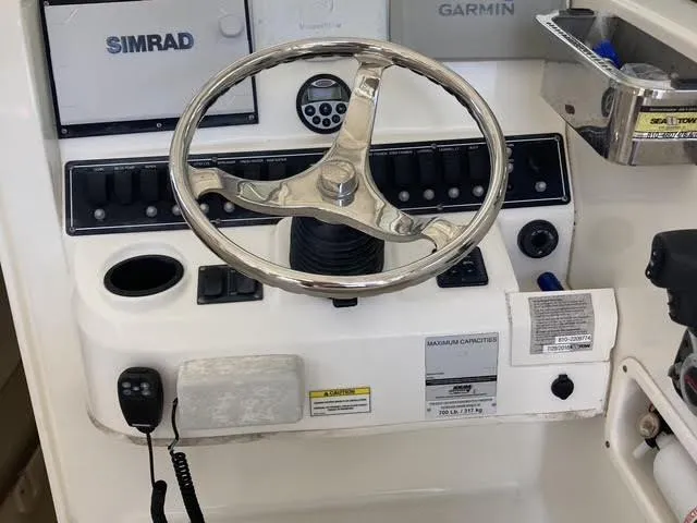 Slide: The Image of 2008 Boston Whaler 235 Conquest helm with steering wheel and navigation controls. - 5