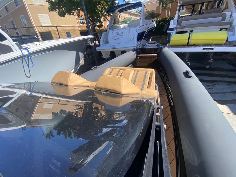 Slide: The Image of 2018 Bernico RX10 boat with tan seats docked among other boats. - 20