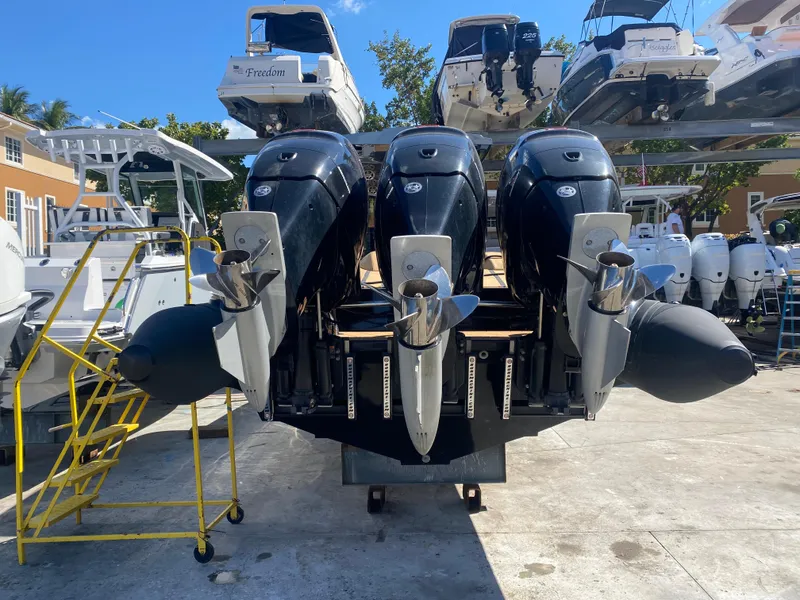 Slide: The Image of Three powerful outboard motors on a 2018 Bernico RX10 boat, parked in a marina. - 23