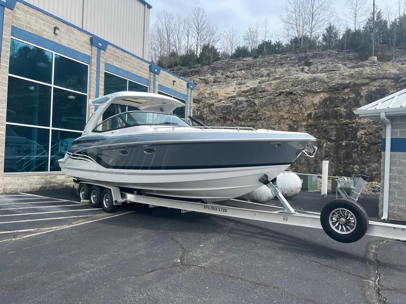 Slide: The Image of 2022 Formula 330 Crossover Bowrider I/O on trailer, parked outside a building. - 1