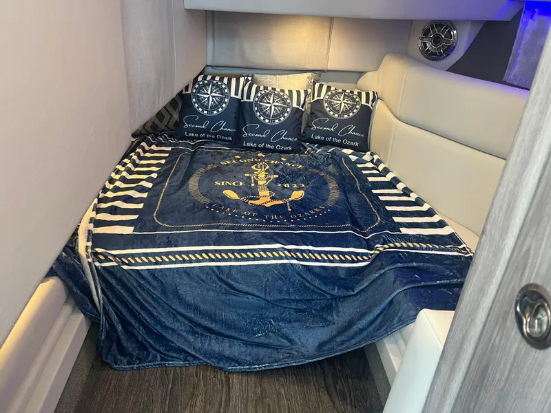 Slide: The Image of Cozy cabin interior of 2022 Formula 330 Crossover Bowrider I/O with nautical-themed bedding. - 17