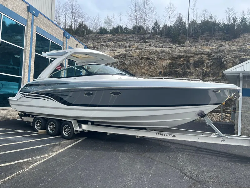 Slide: The Image of 2022 Formula 330 Crossover Bowrider I/O on trailer, parked outdoors. - 2