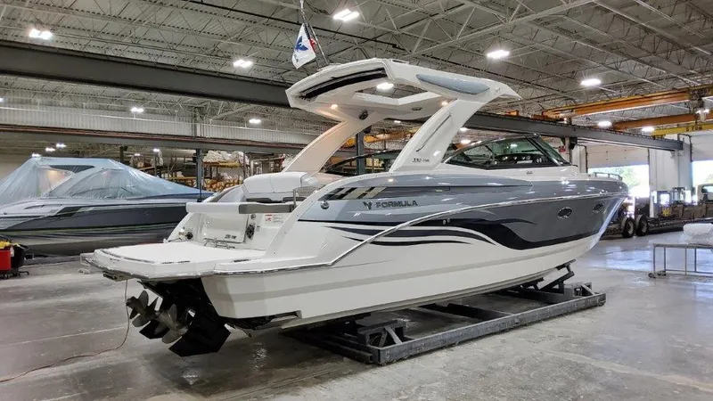 Slide: The Image of 2022 Formula 330 Crossover Bowrider I/O in a spacious indoor showroom. - 21