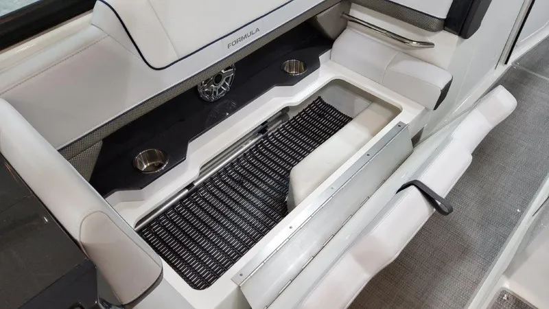 Slide: The Image of 2022 Formula 330 Crossover Bowrider I/O interior with open storage compartment and cup holders. - 46