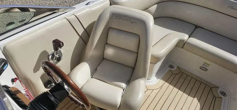 Slide: The Image of 2007 Chris-Craft Launch 22 boat interior with beige seating and wooden steering wheel. - 13