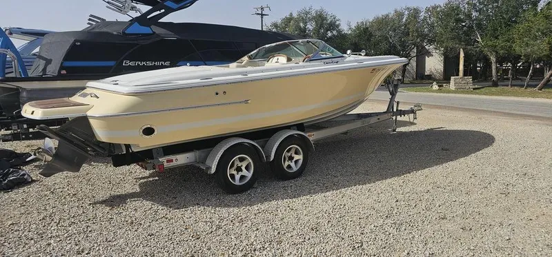 Slide: The Image of 2007 Chris-Craft Launch 22 boat on trailer, parked on gravel, side view. - 2