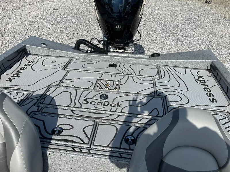 Slide: The Image of 2022 Xpress X19 Pro boat deck with SeaDek flooring and motor, featuring sleek design. - 13