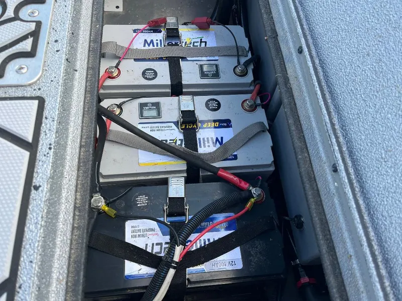 Slide: The Image of Batteries installed in a 2022 Xpress X19 Pro boat, secured with straps and connected with cables. - 16