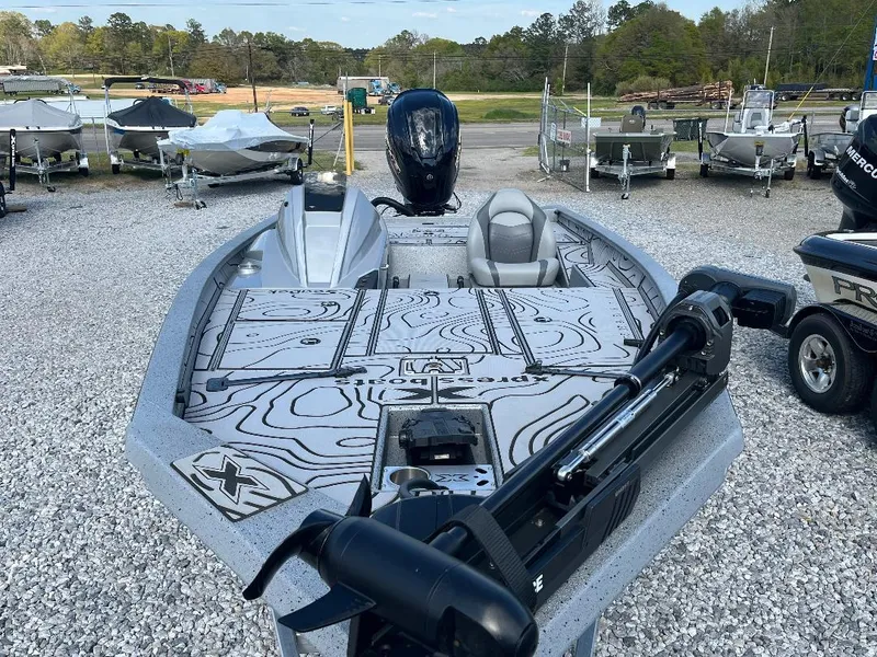 Slide: The Image of 2022 Xpress X19 Pro boat with sleek design, parked on gravel lot. - 3