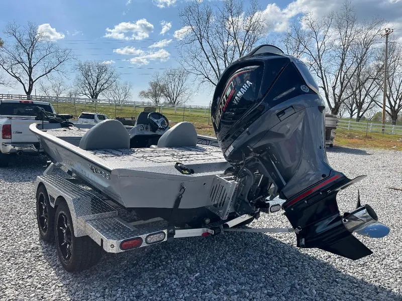 Slide: The Image of 2022 Xpress X19 Pro boat on trailer with powerful outboard motor, parked on gravel. - 7
